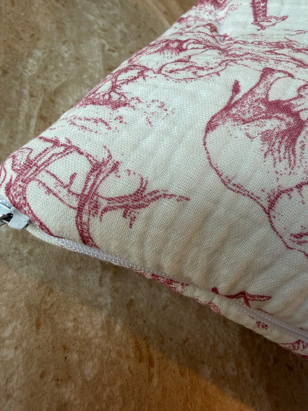 Gros plan sur le motif en toile de Jouy rose et la fermeture éclair de la trousse de toilette Safari rose