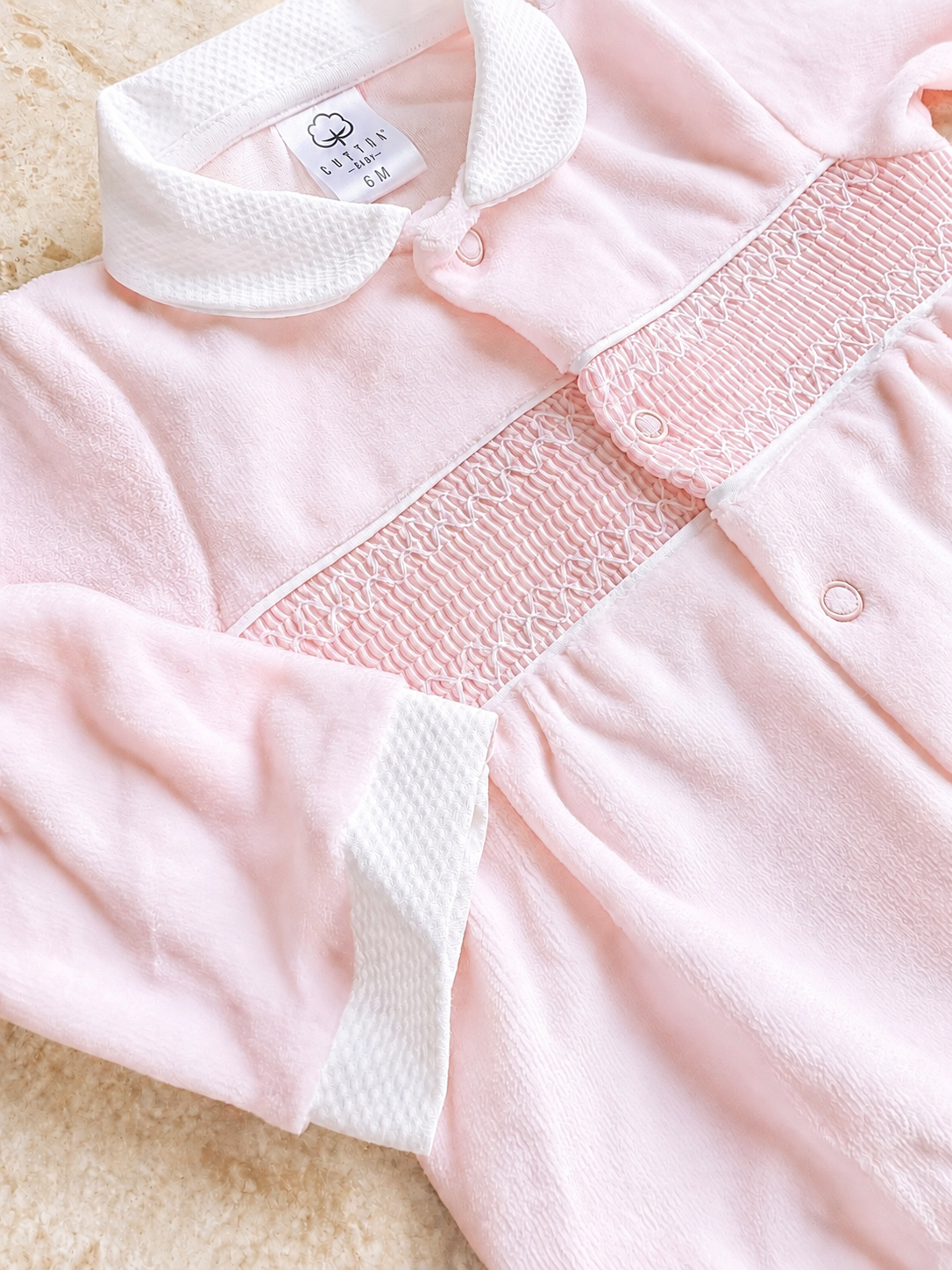 Détail de l’empiècement smocké et des boutons du pyjama bébé Charlie rose poudré