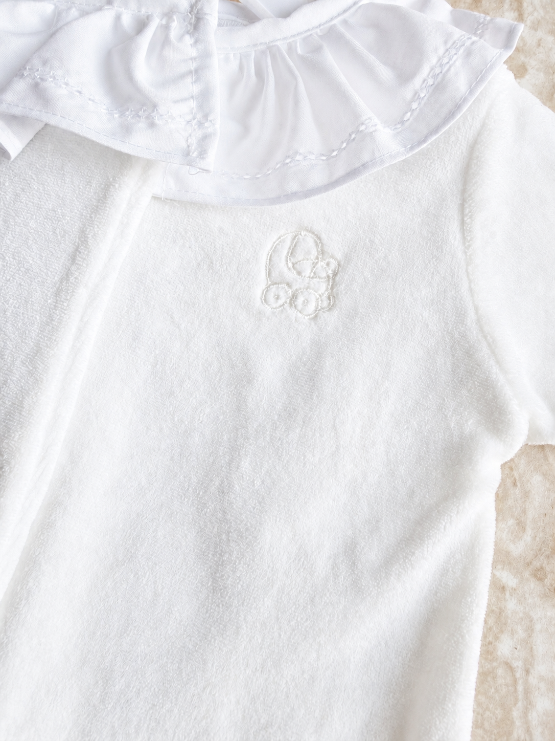 Gros plan sur le velours et la broderie ton sur ton du pyjama Lola