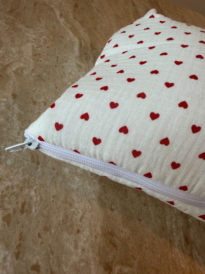 Gros plan sur le motif à petits cœurs rouges et la fermeture éclair de la trousse de toilette Petit Cœur