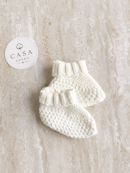 Chaussons bébé Noa en maille blanche, présentés à plat