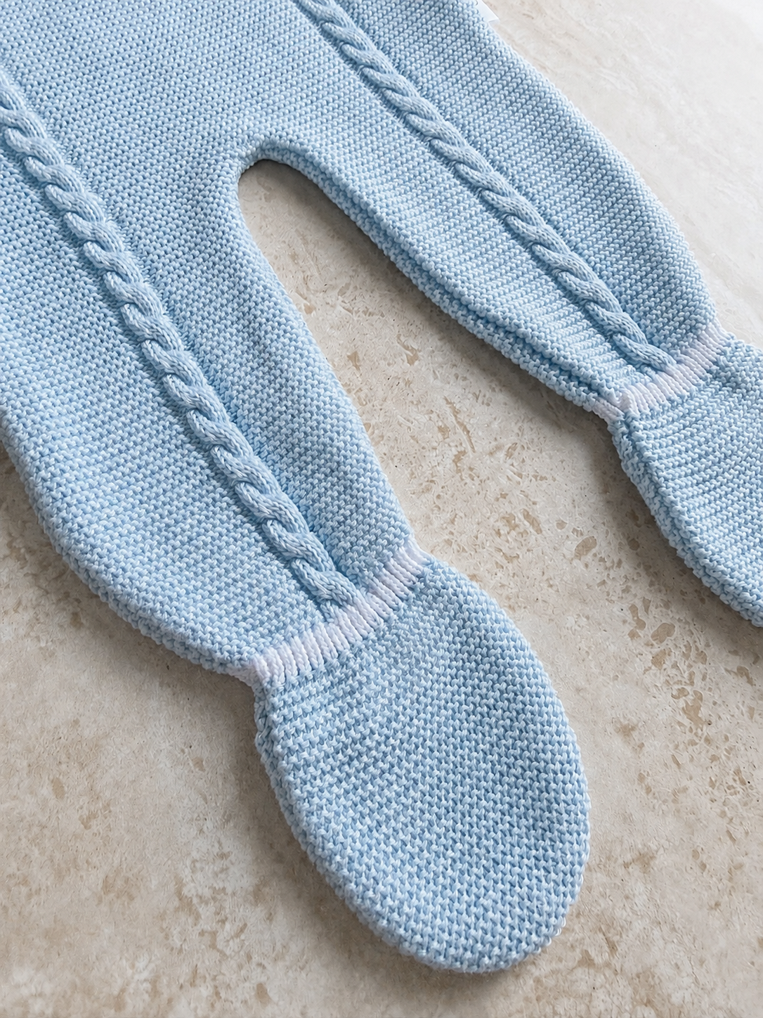 Détail de la maille torsadée et de la bretelle de la salopette bébé Gabriel bleue