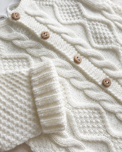Détail des boutons et de la maille torsadée de la combinaison bébé Noa blanche
