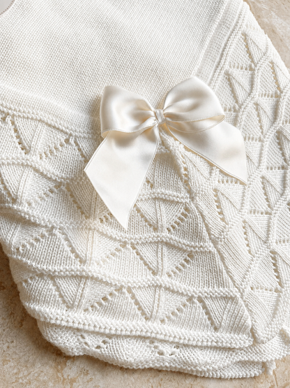 Détail du point ajouré et du nœud satin de la couverture bébé Luna blanche