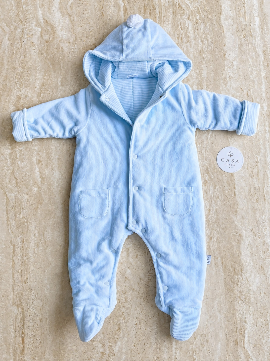 Combinaison pilote bébé Leon bleu ciel à capuche, présentée à plat