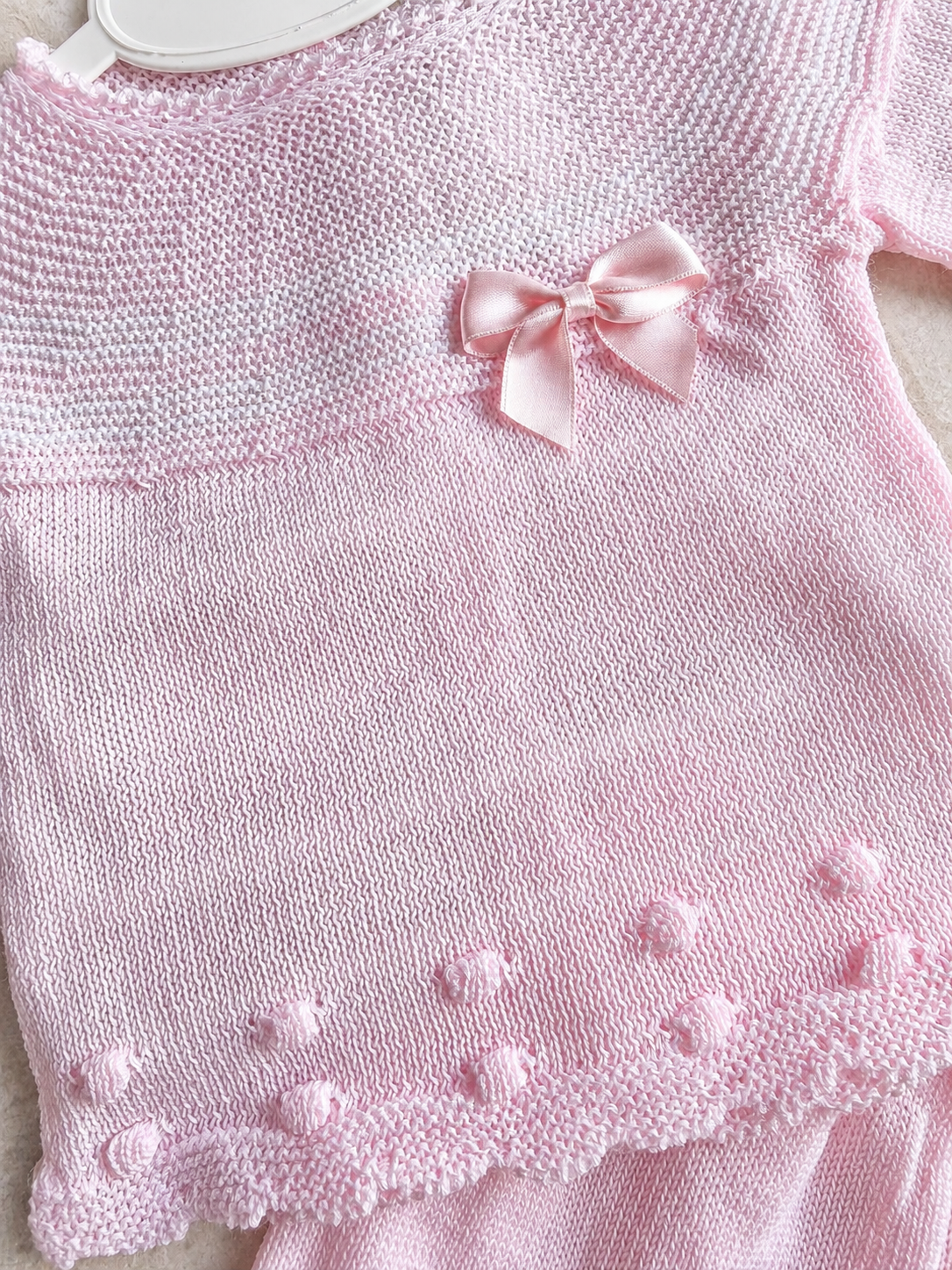 Détail des pois brodés et du nœud de l’ensemble bébé Elena rose