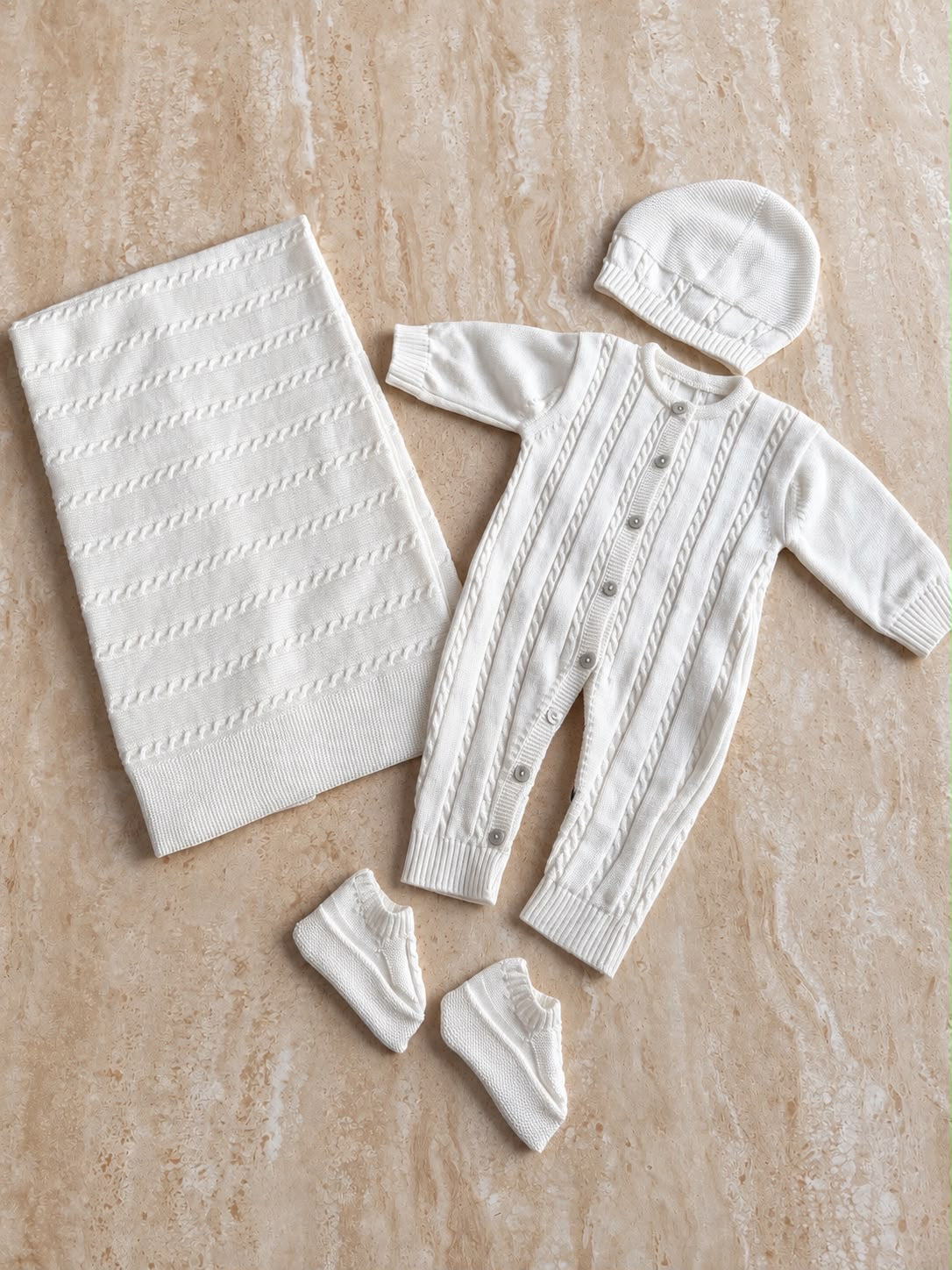 Ensemble de naissance en maille blanche, pièces présentées à plat, prénom brodé