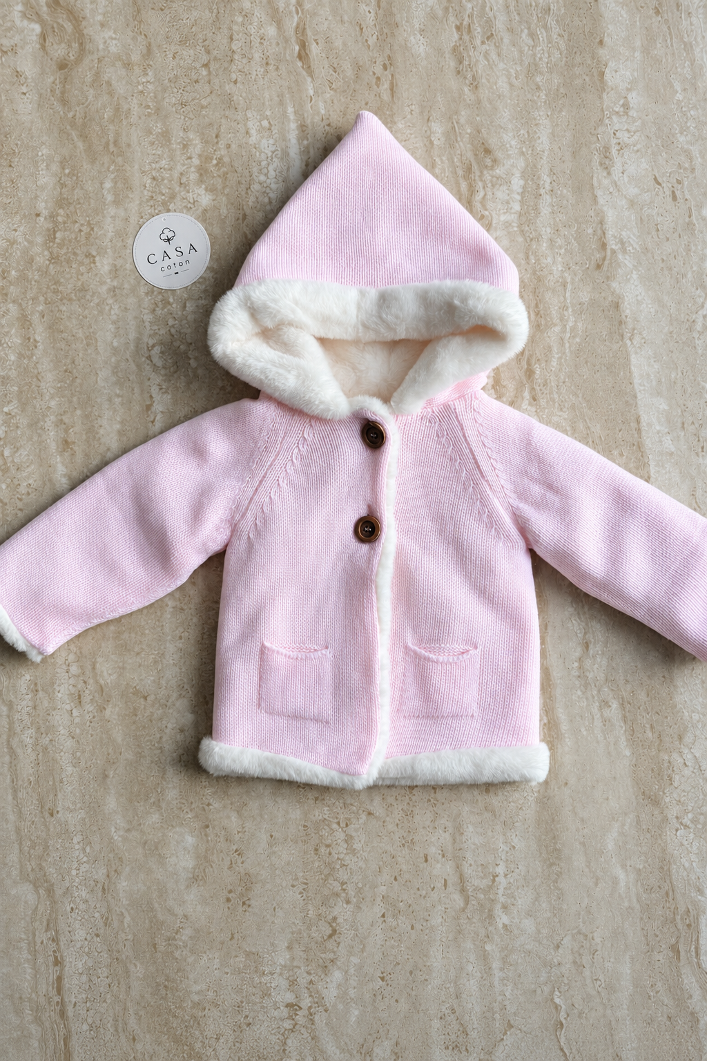 Manteau bébé Ava en maille rose à capuche, présenté à plat