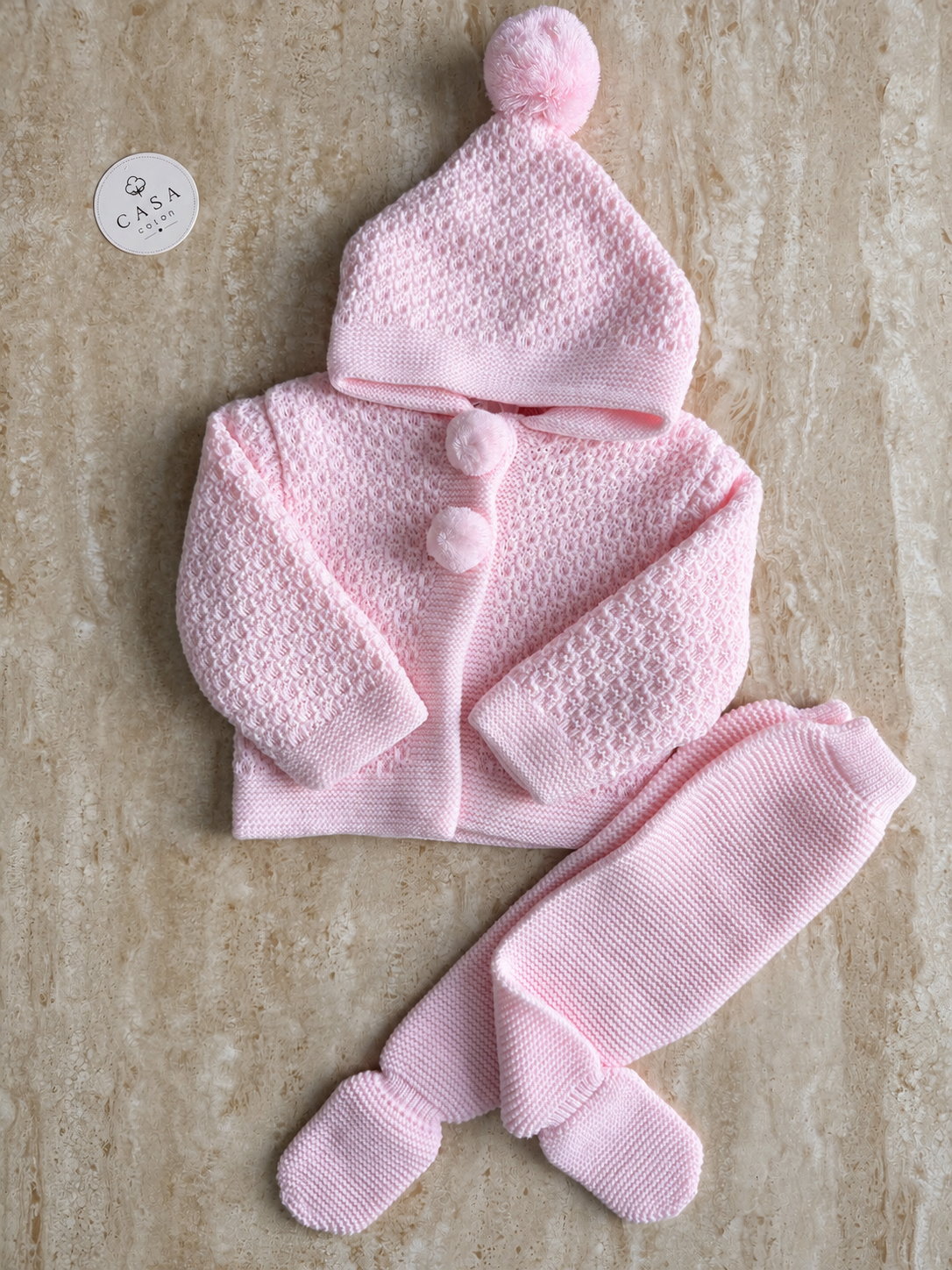 Ensemble bébé Mia en maille rose : brassière, pantalon et bonnet présentés à plat