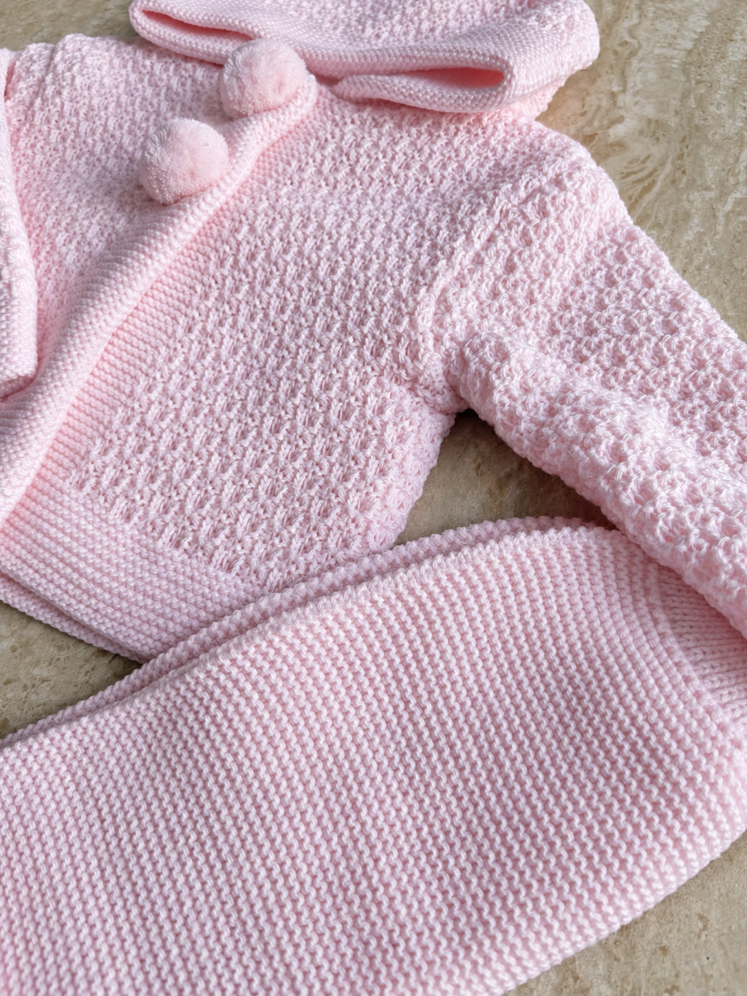 Détail de la maille et des boutons de l’ensemble bébé Mia rose