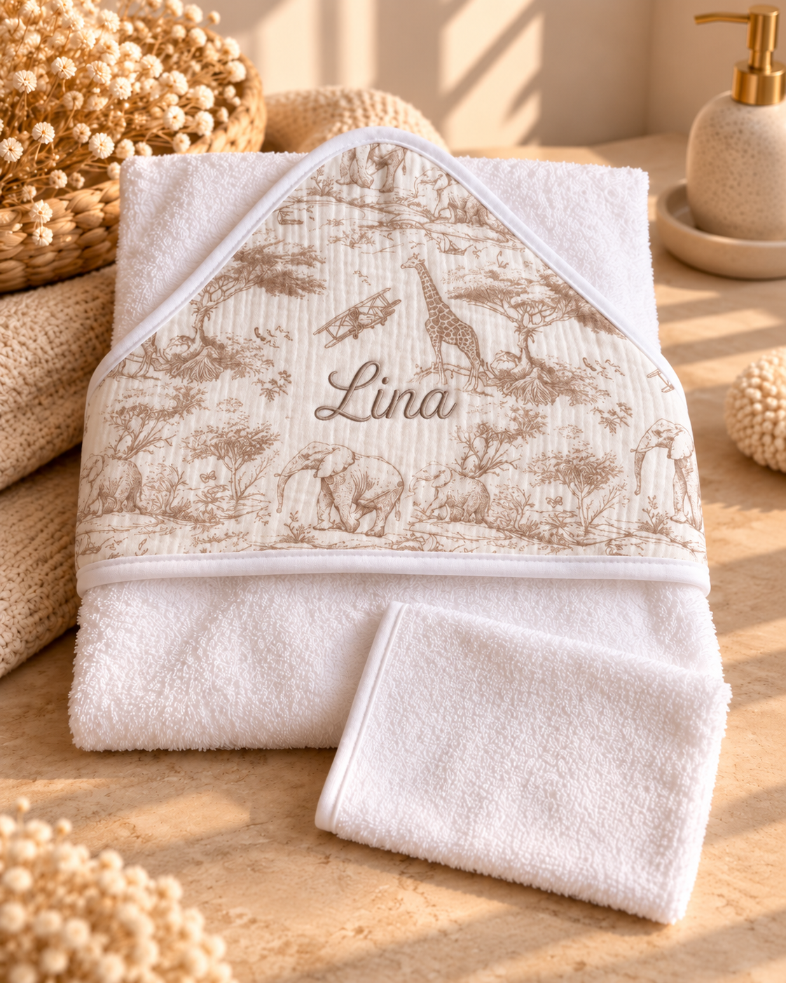 Cape de bain Safari en toile de Jouy beige, posée à plat avec son gant de toilette