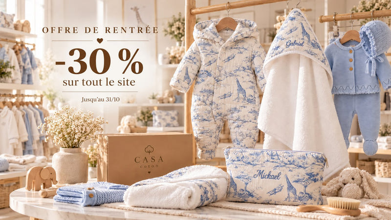 Coffret Casa Coton ouvert sur un ensemble bébé en maille rose brodé au prénom, avec son bonnet et ses chaussons assortis